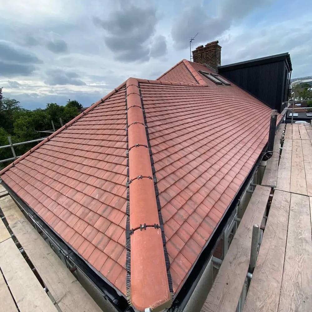 A newly finished red tiled hip roof by Top Level Roofing