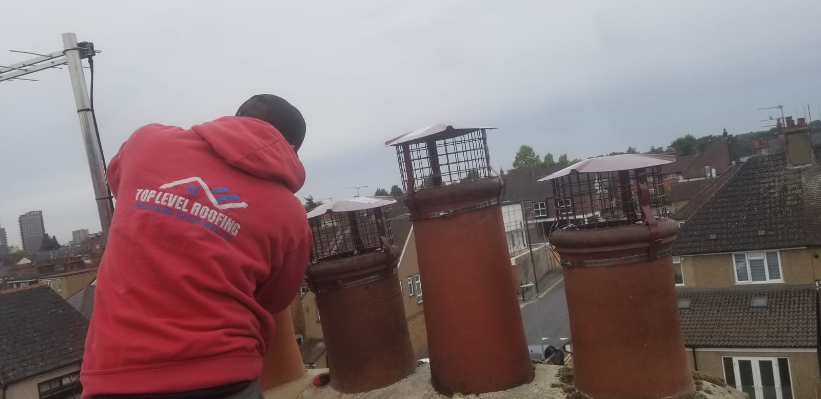 A Top Level Roofing team member fitting new chimney cowls