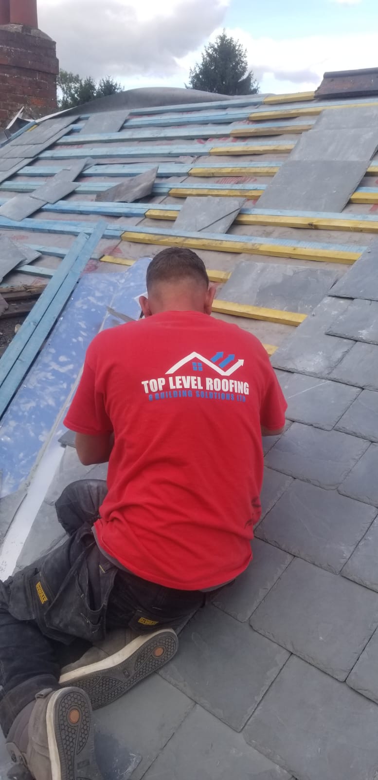 A Top Level Roofing team member laying a slate roof