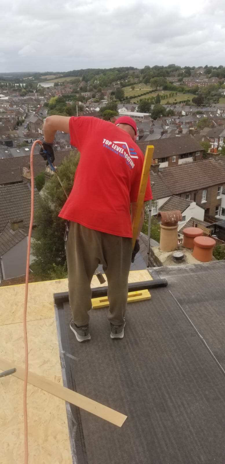 A Top Level Roofing team member installing a felt flat roof
