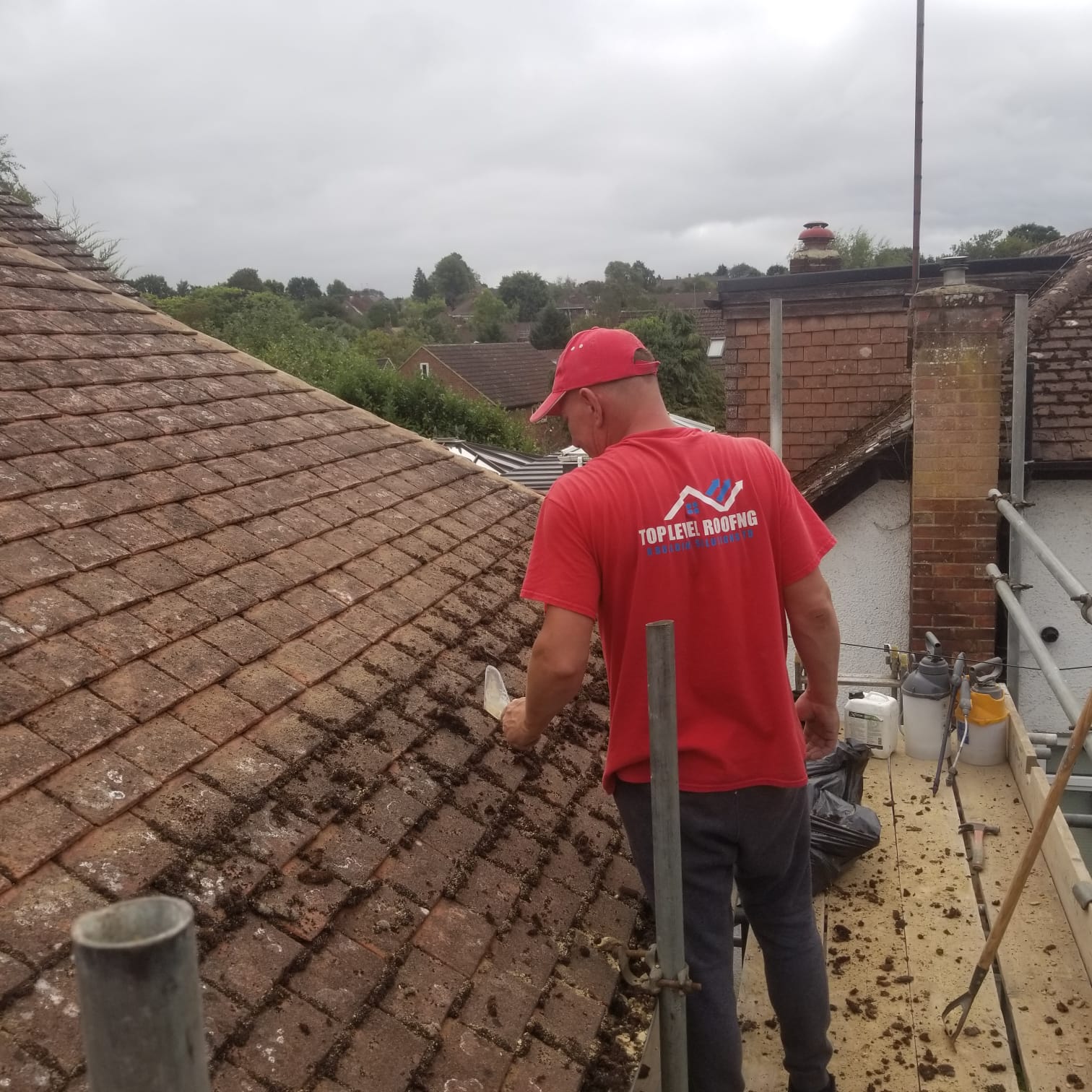 A Top Level Roofing team member repointing a tiled roof