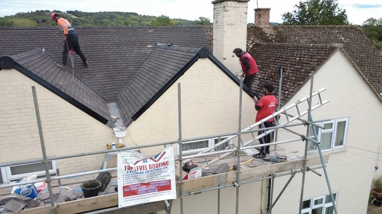 The Top Level Roofing team re-roofing a house from scaffold