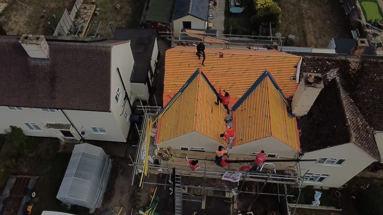 Aerial view of a tiled roof mid-replacement with the team on site by Top Level Roofing & Building Solutions