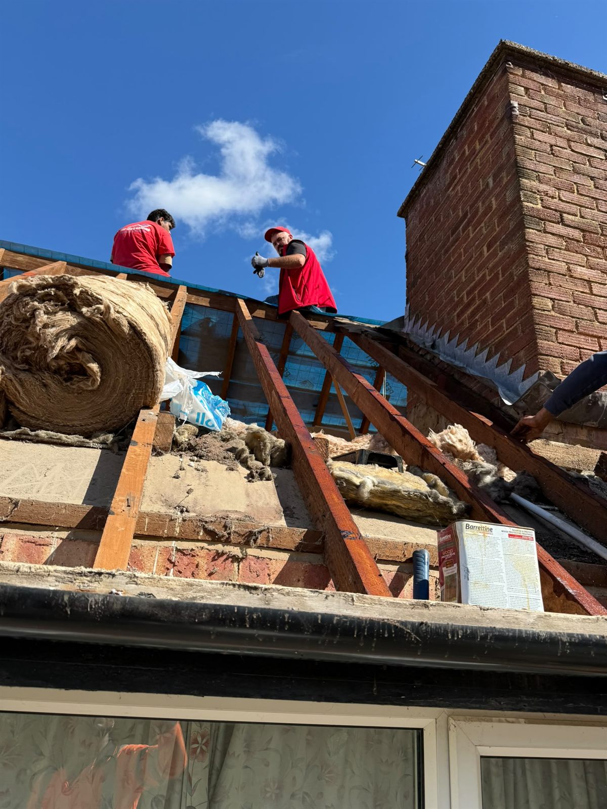 Two Top Level Roofing team members on a stripped roof during a re-roof