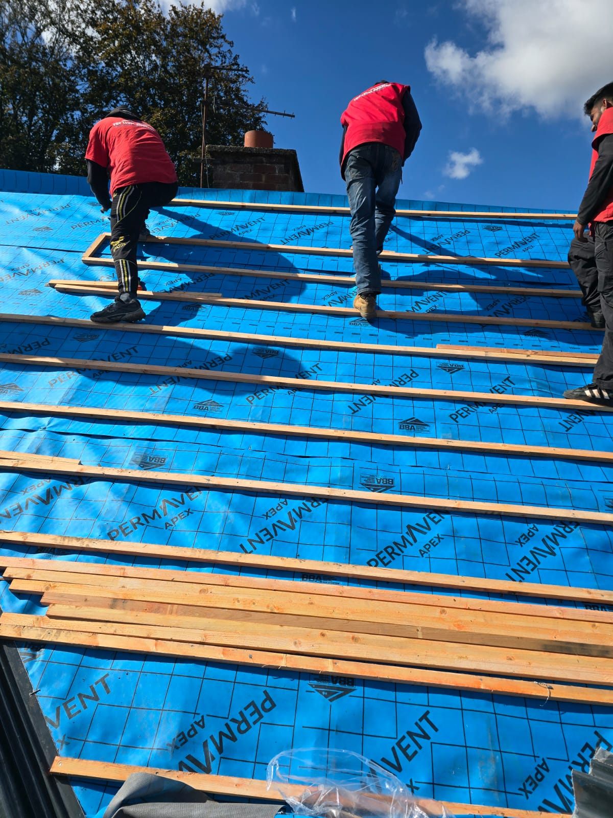 The Top Level Roofing team battening a roof over new membrane