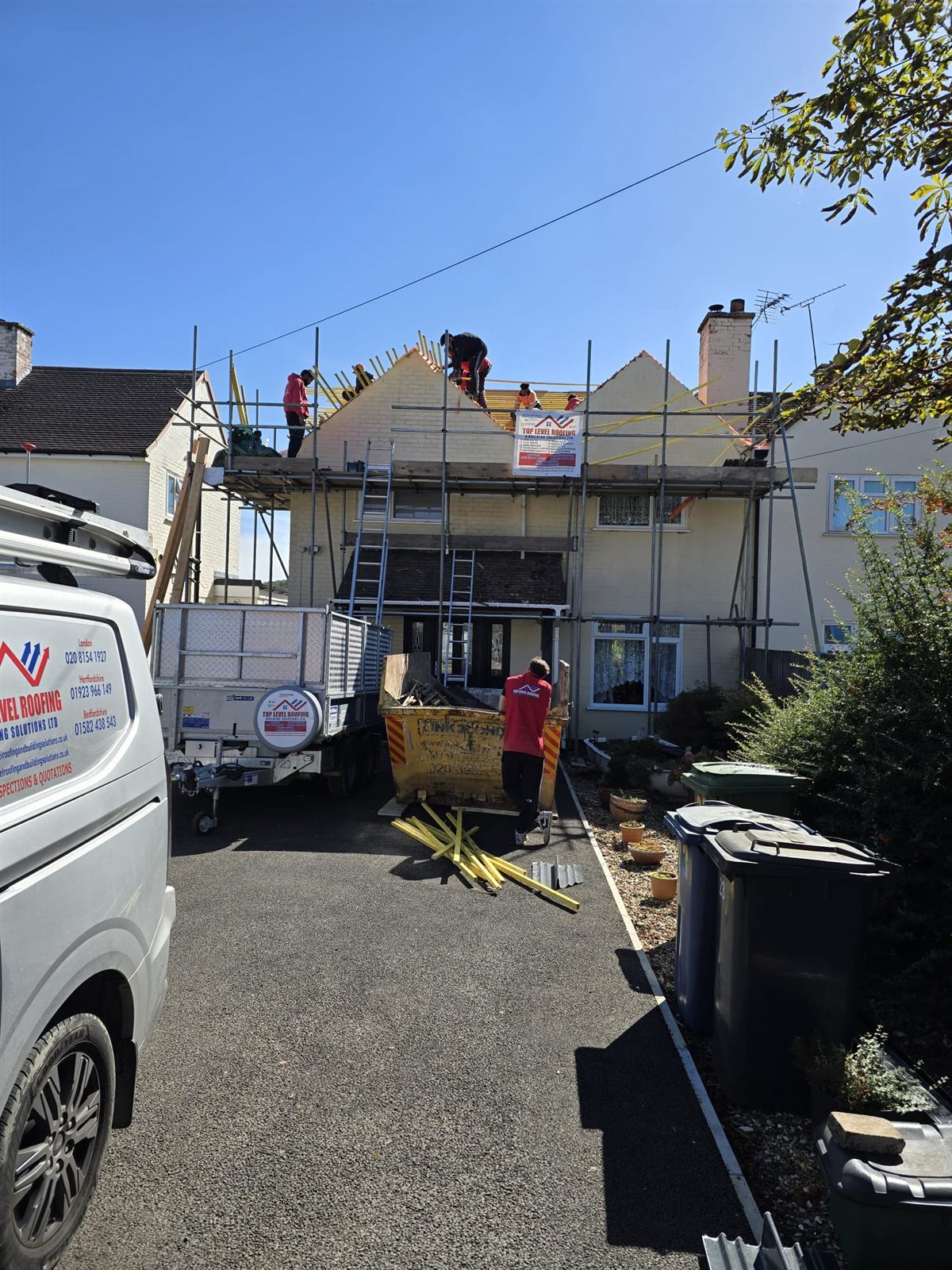 The Top Level Roofing team and branded van on a re-roof