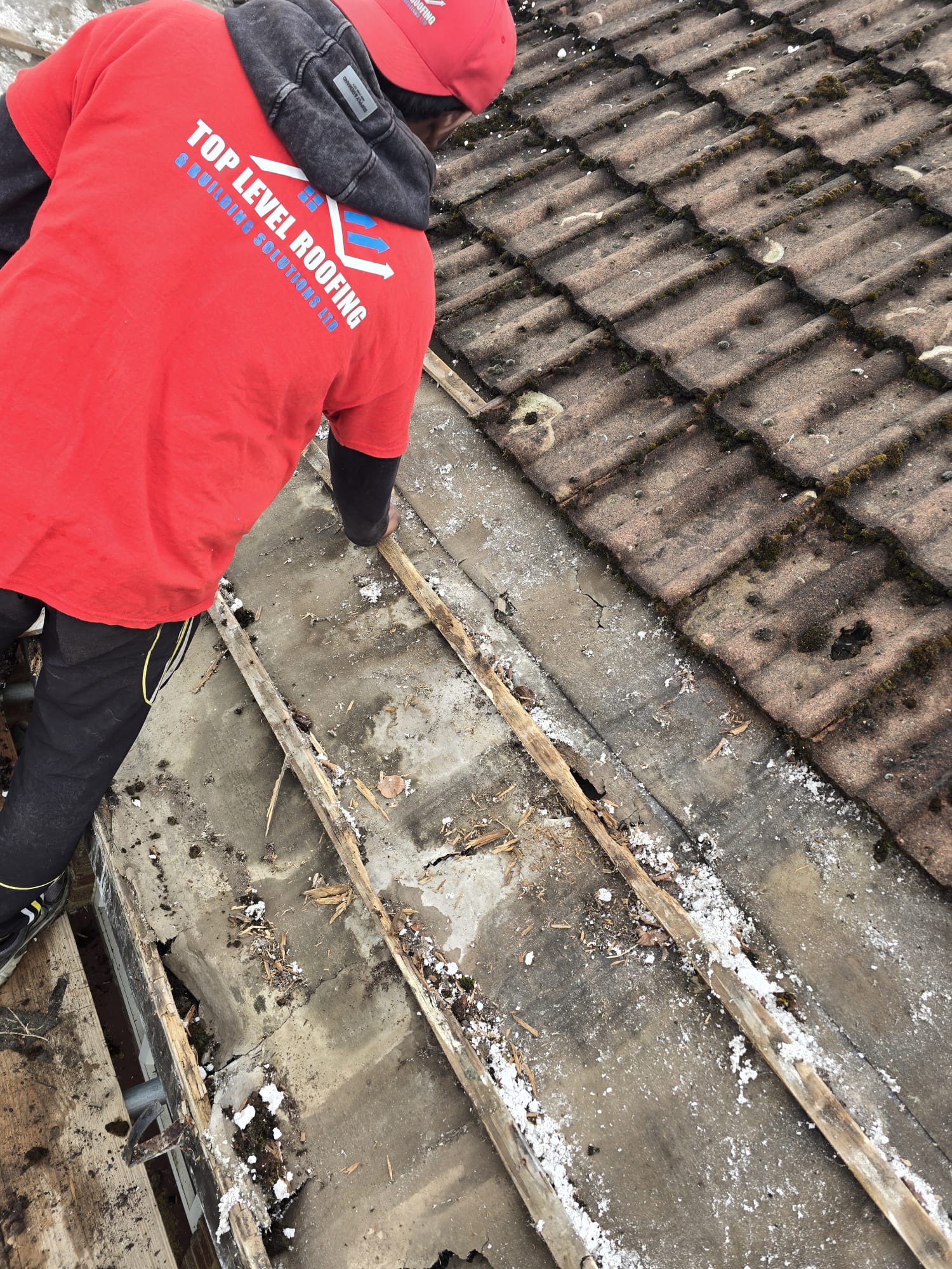 Spray foam insulation applied under a roof, ready for removal